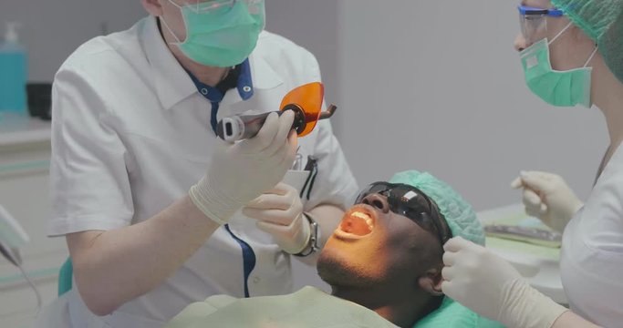 patient at dentist has ultraviolet filling done