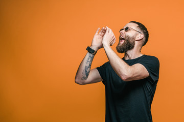Young man keeping hand near mouth and screaming and poin for your text. Your text here. Sales!