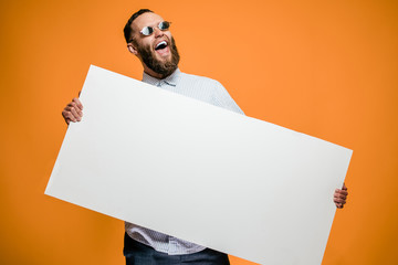 Hipster man holding a poster with blank space for your text.