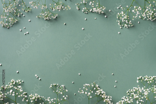 Small white gypsophila flowers on pastel green background. Women's Day, Mother's Day, Valentine's Day, Wedding concept. Flat lay. Top view. Copy space