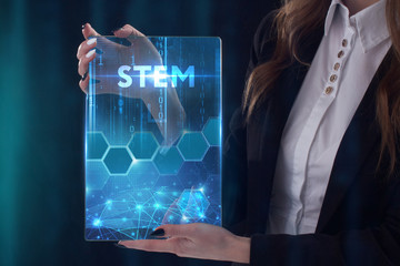 The concept of business, technology, the Internet and the network. A young entrepreneur working on a virtual screen of the future and sees the inscription: STEM