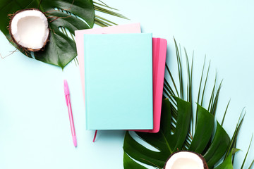 Fototapeta na wymiar Female blog writer workspace concept. Green monstera palm leaves, coconut on pink background with copy space. Banner. Flat lay, top view.
