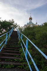 Fototapeta na wymiar blue metal staircase with steps leading to the temple which stands on the mountain