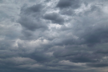 In the sky the storm clouds, and the clouds. Bad weather. Strong wind and feeling the rain. The clouds are dark blue. The clouds are lit by sunlight.