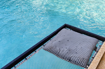 Mesh seat with pillows jut out on swimming pool