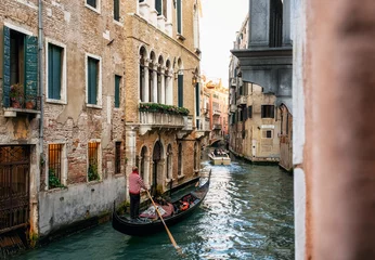 Wall murals Gondolas Venetian gondolier punts gondola through narrow canal waters of Venice Italy