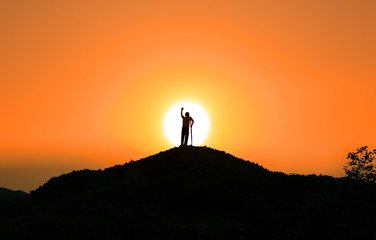 Refugee concept: a disabled person standing on the top of the mountain at sunset