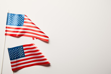 Obraz premium top view of bright american flags on white background with copy space
