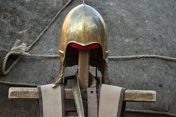 Antique military bronze helmet with a brilliant gold surface on a pole