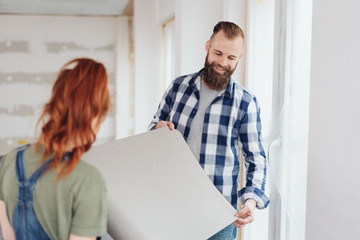 Young couple deciding on wallpaper for renovations