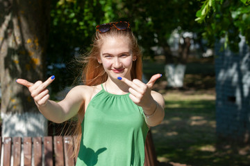 Cheerful girl making gun shot gesture. girl showing middle finger offensive gesture. Woman showing...