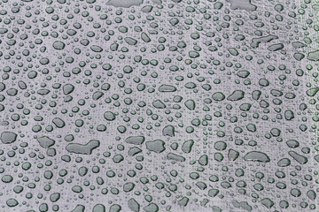 Large drops of water on plastic film after rain