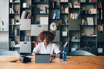 young black student working with tablet on a project in coworking office