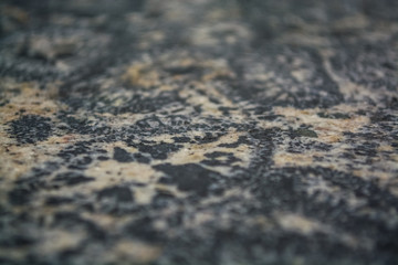Background or texture from a gray stone with round spots and stains. Natural material. Glossy surface.