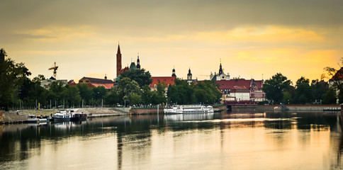 Obraz premium View of St. John the Baptist cathedral and other historic buildings in old town Wroclaw from Oder (Odra) river