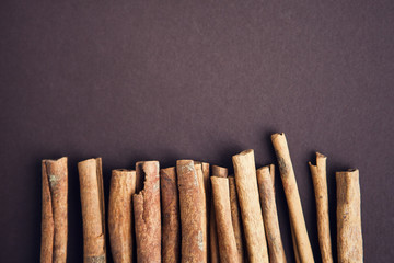 Set of cinnamon sticks on brown background