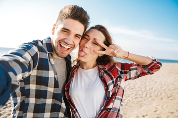 Happy young loving couple outside in free alternative vacation camping take selfie by camera.