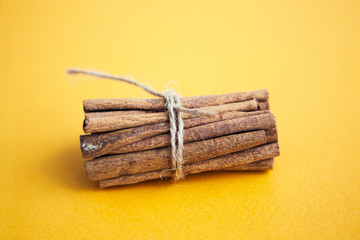 Set of cinnamon sticks on yellow background