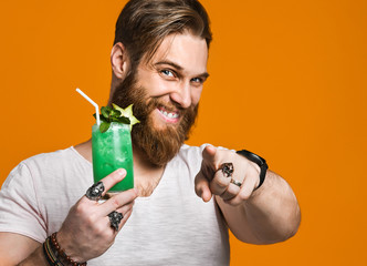 Young man holding a multicolored cocktail