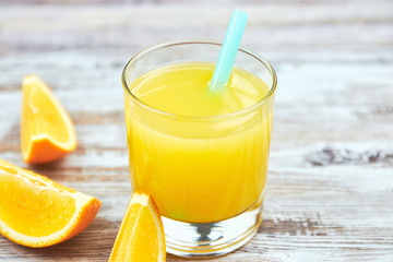 Fresh orange juice in a glass and orange slices on a shabby table light. horizontal view. detox. close-up. Copy space citrus refreshing drink.