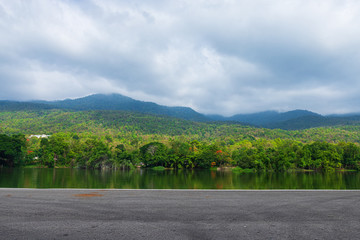 Fototapeta premium Along road landscape view in Ang Kaew Chiang Mai University Forested Mountain blue sky background with white clouds, Nature Road in mountain forest.