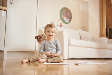 Fototapeta premium Adorable little boy with pencil sitting on the floor