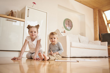 Adorable children drawing with pencils at home