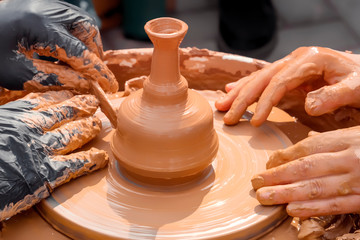 Master-class on clay modeling on a potter's wheel in a workshop on the street. Close-up