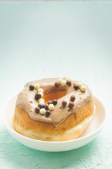 Donat. A plate with appetizing donat of glaze. Fresh pastries.