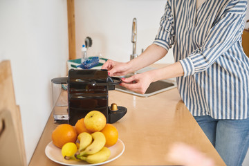 Young woman making coffee for breakfast at home