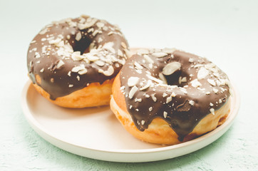 Donats. A plate with appetizing donata in chocolate glaze. Fresh pastries.