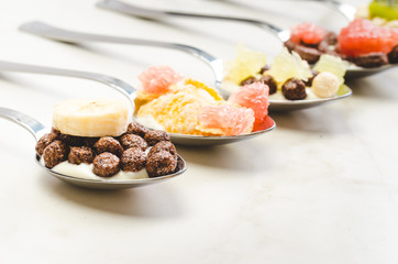 Healthy food concept. Yogurt, flakes and fruit in spoons