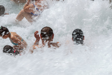 Saturnia, Italy. 04-28-2019. People bathing in natural spa of the hot Mill waterfalls of  cascate...