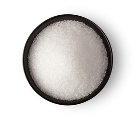 Bowl of white sugar isolated on white background, top view