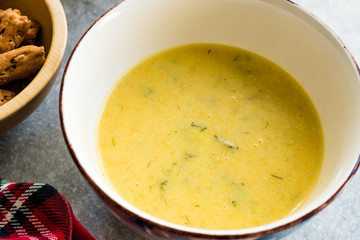 Homemade Zucchini and Carrot Soup with Crispy Bread at Lunch Table.