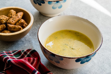 Homemade Zucchini and Carrot Soup with Crispy Bread at Lunch Table.
