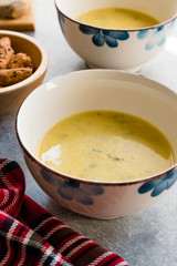 Homemade Zucchini and Carrot Soup with Crispy Bread at Lunch Table.