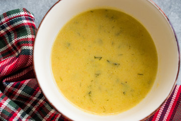 Homemade Zucchini and Carrot Soup with Crispy Bread at Lunch Table.