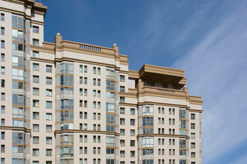 Fototapeta premium Facade of a multi-storey apartment building against the blue sky