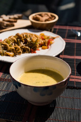 Homemade Zucchini and Carrot Soup with Crispy Bread at Lunch Table.