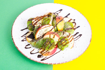 Tasty fruit salad on bright pastel background