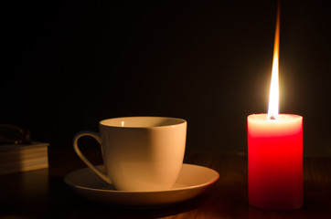 .Coffee cup and candle light Black background