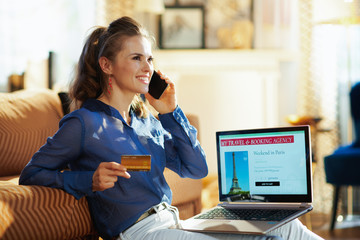 woman with travel site holding credit card talking on mobile