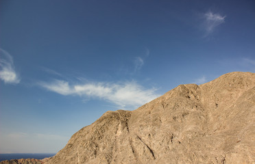 dry sand stone desert mountain shape silhouette on blue sky background 