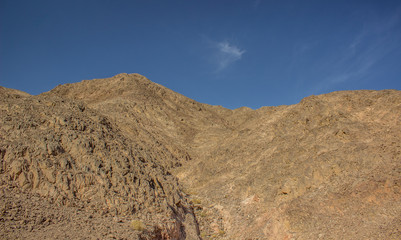 dry sand stone desert mountain shape silhouette on blue sky background 