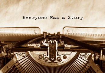 Everyone Has a Story printed on a sheet of paper on a vintage typewriter. literature, writer.