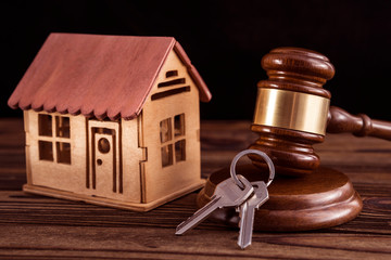 wooden house, judge hammer, keys on wooden background. legal right to real estate.