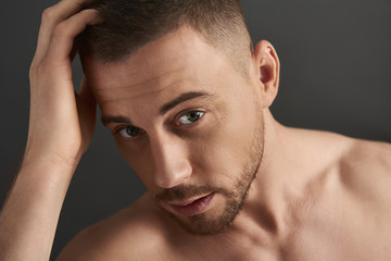 Obraz premium Portrait of handsome bearded young man after having shower looking at camera