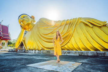 Happy woman tourist on background ofLying Buddha statue