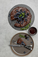 Fototapeta na wymiar Piece of chocolate cake with whole cake on gray background